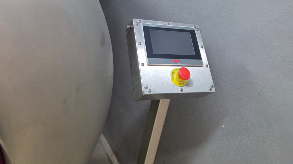 Control panel with a red and yellow button on a gray background