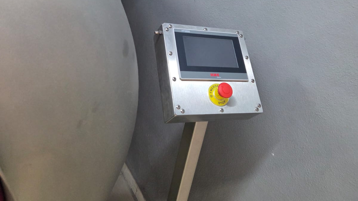 Control panel with a red and yellow button on a gray background