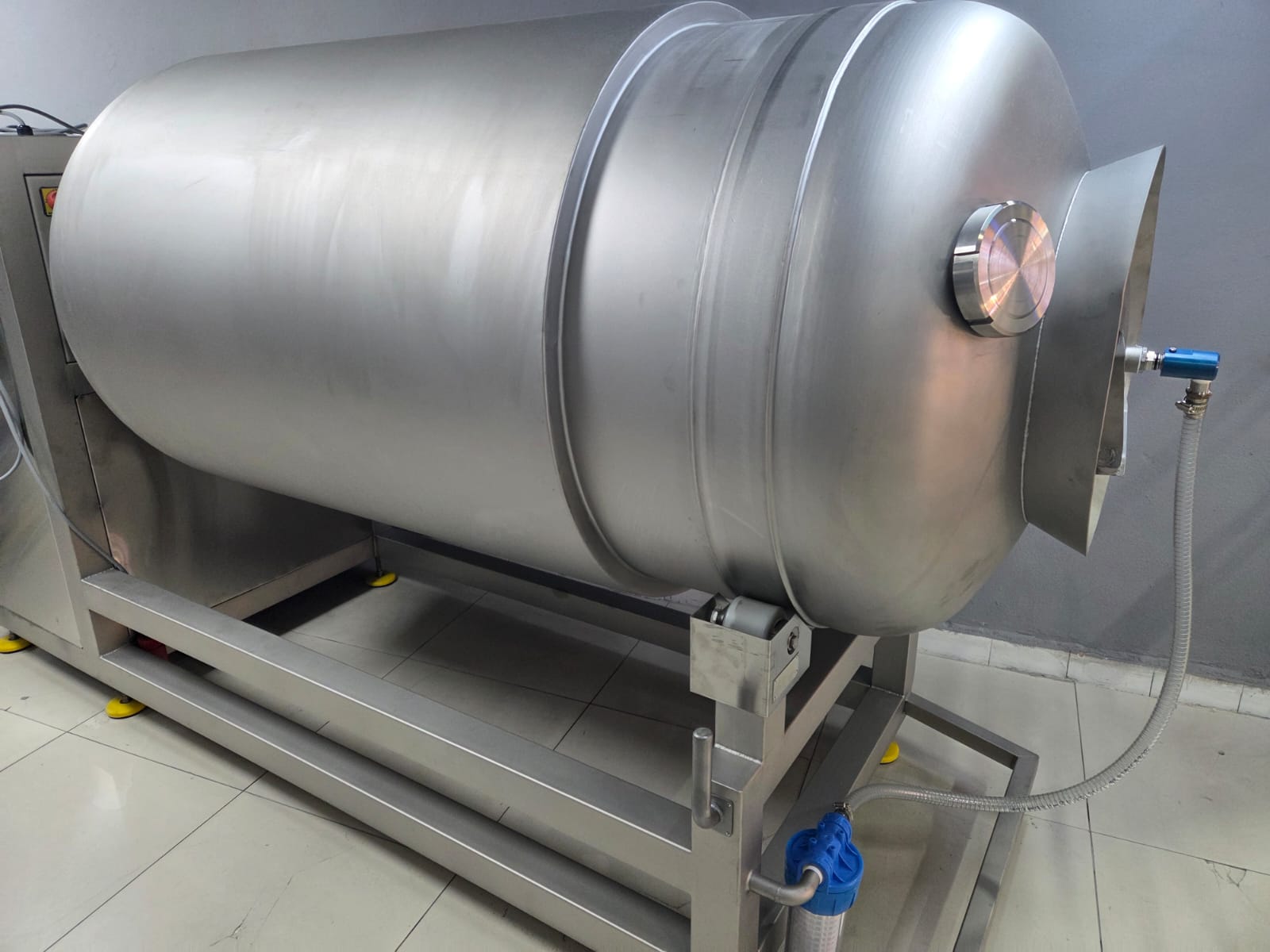 Large metallic tank with a pressure gauge on a tiled floor