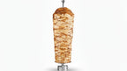 Doner kebab on a vertical rotating spit against a white background