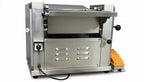 Commercial dough sheeter on a wooden table with a gray background